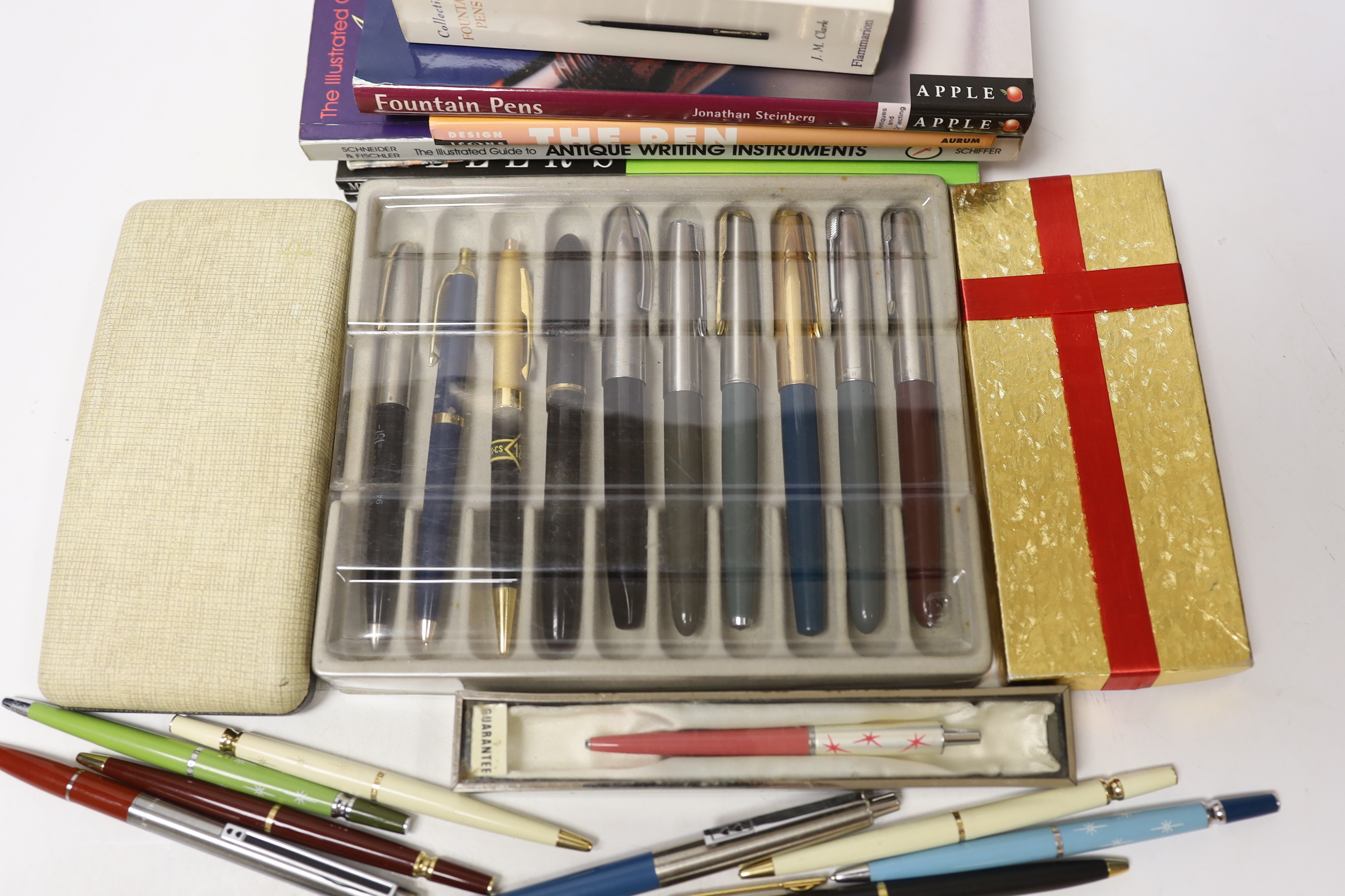 A collection of pens including Parker and pen-related publications